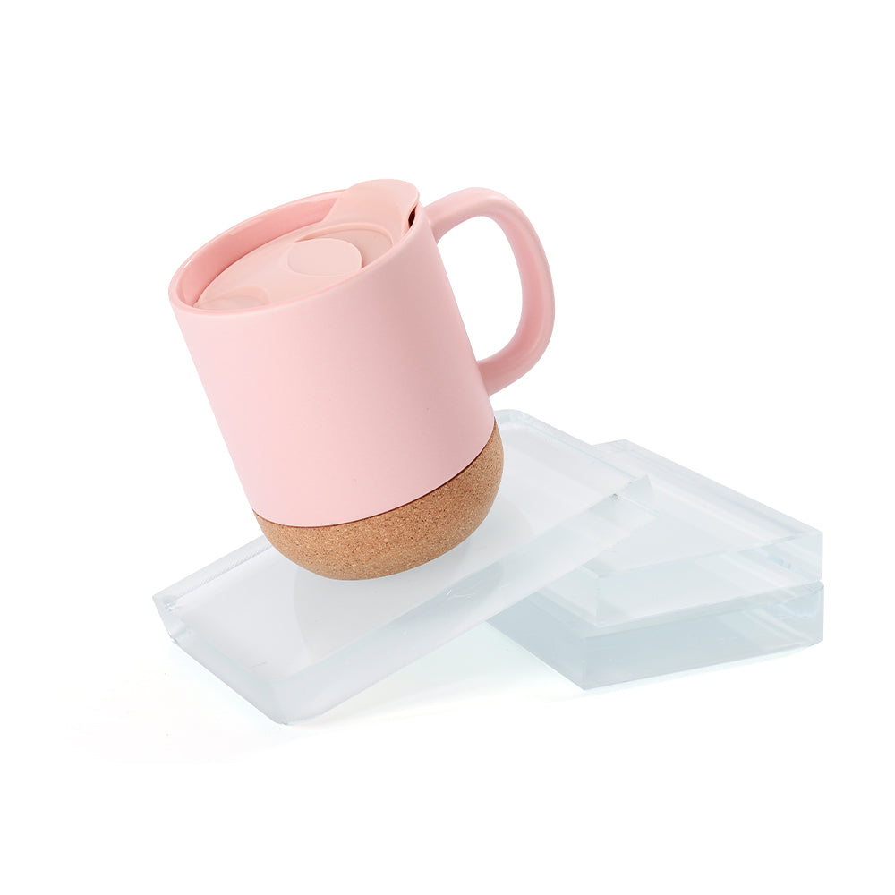 Matte pink 13oz sublimation mug with cork base and lid, displayed on acrylic blocks for showcasing eco-friendly drinkware design.