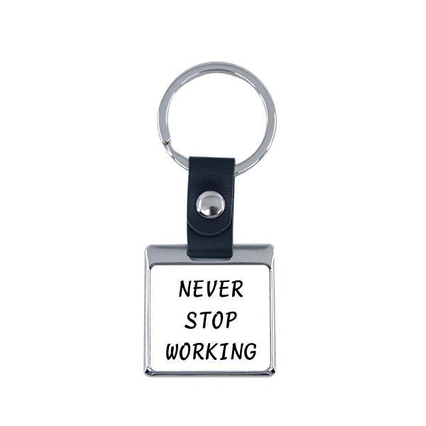 Square metal sublimation keyring with black strap and 'Never Stop Working' text, blank for engraving or printing.