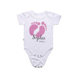 White sublimation baby bodysuit with pink baby footprints and custom text for laser engraving