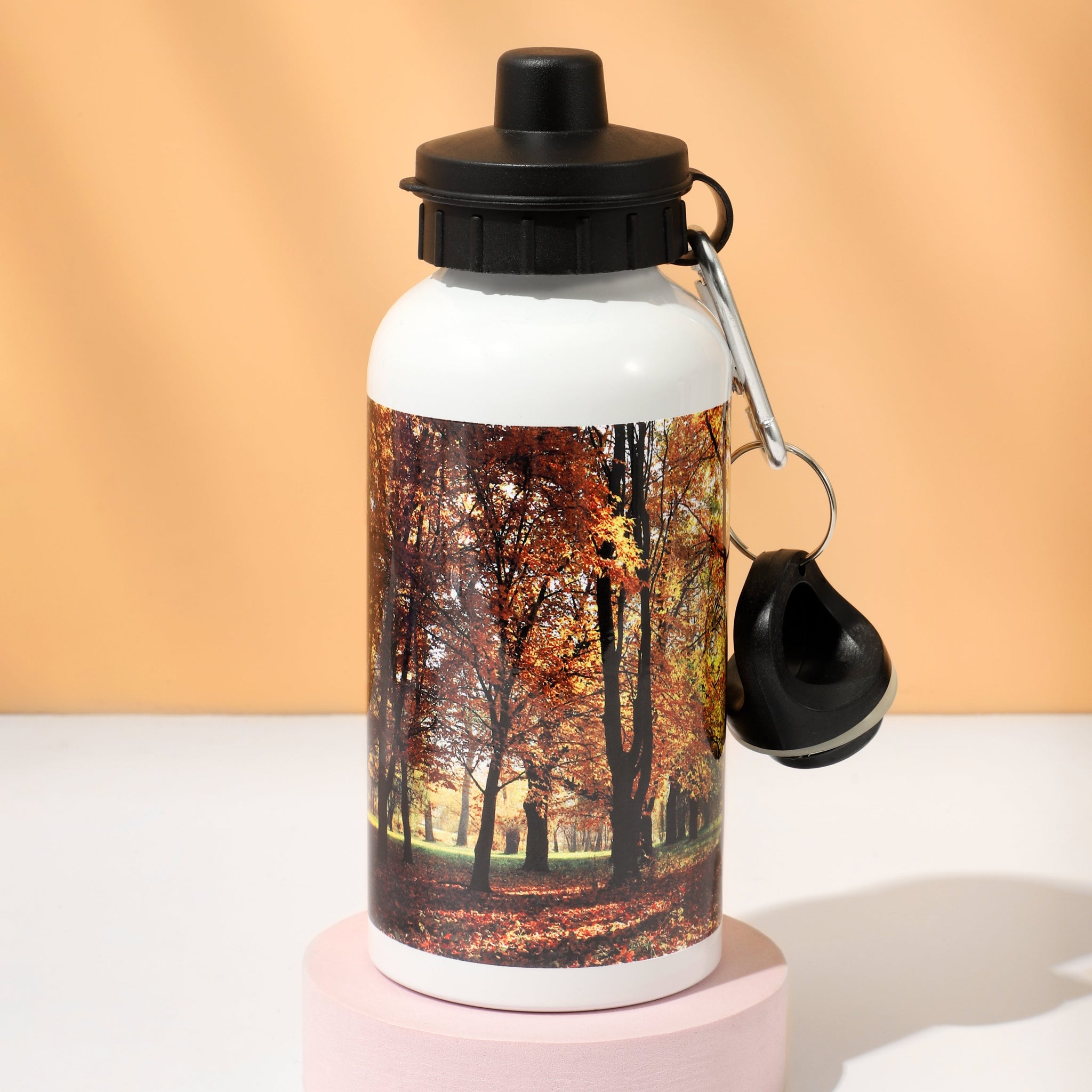 White aluminium sublimation water bottle with autumn forest print, black cap and carabiner