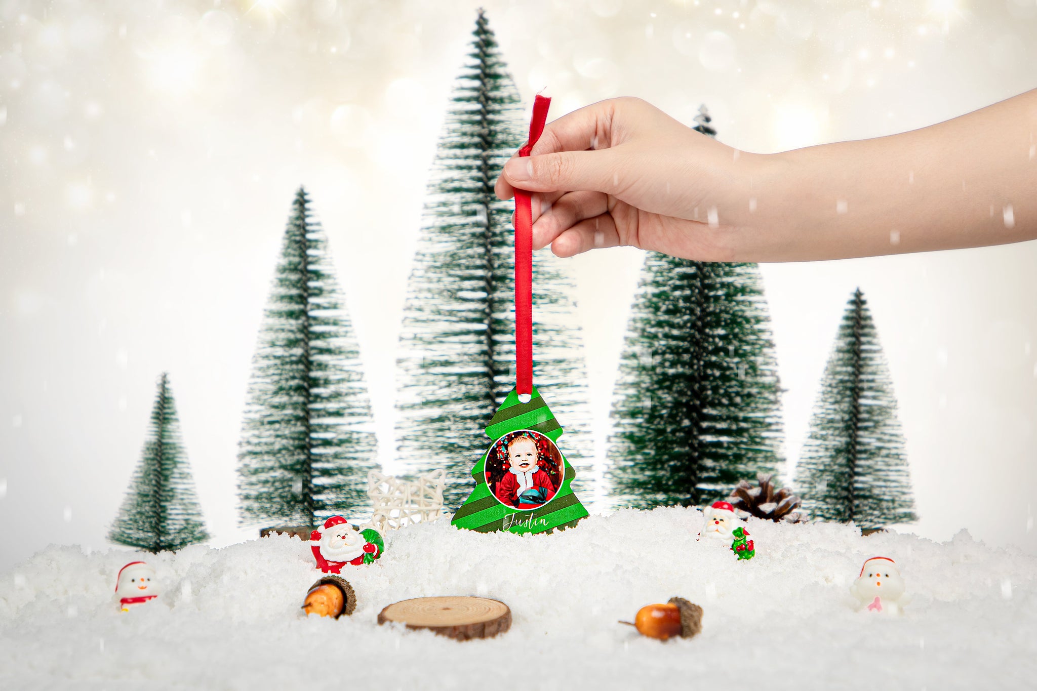 Hand holding double-sided aluminium Christmas tree ornament for sublimation in snowy scene