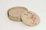 Round burlap coasters set in holder, one with floral sublimation print, blank for engraving