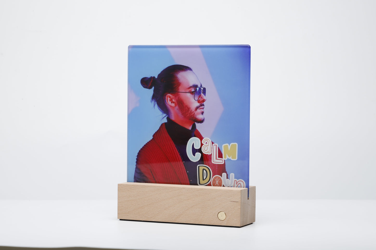 Glass Photo panel with LED Base showcasing a vibrant sublimated image of a man, illuminated from below by the wooden LED light base.