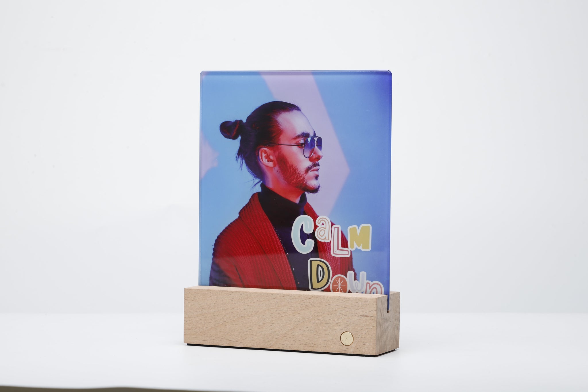 Glass Photo panel with LED Base showcasing a vibrant sublimated image of a man, illuminated from below by the wooden LED light base.