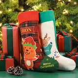 Linen red Christmas stocking with elf and reindeer cartoon, sublimation blank ready for personalization, set by Christmas tree with gifts.