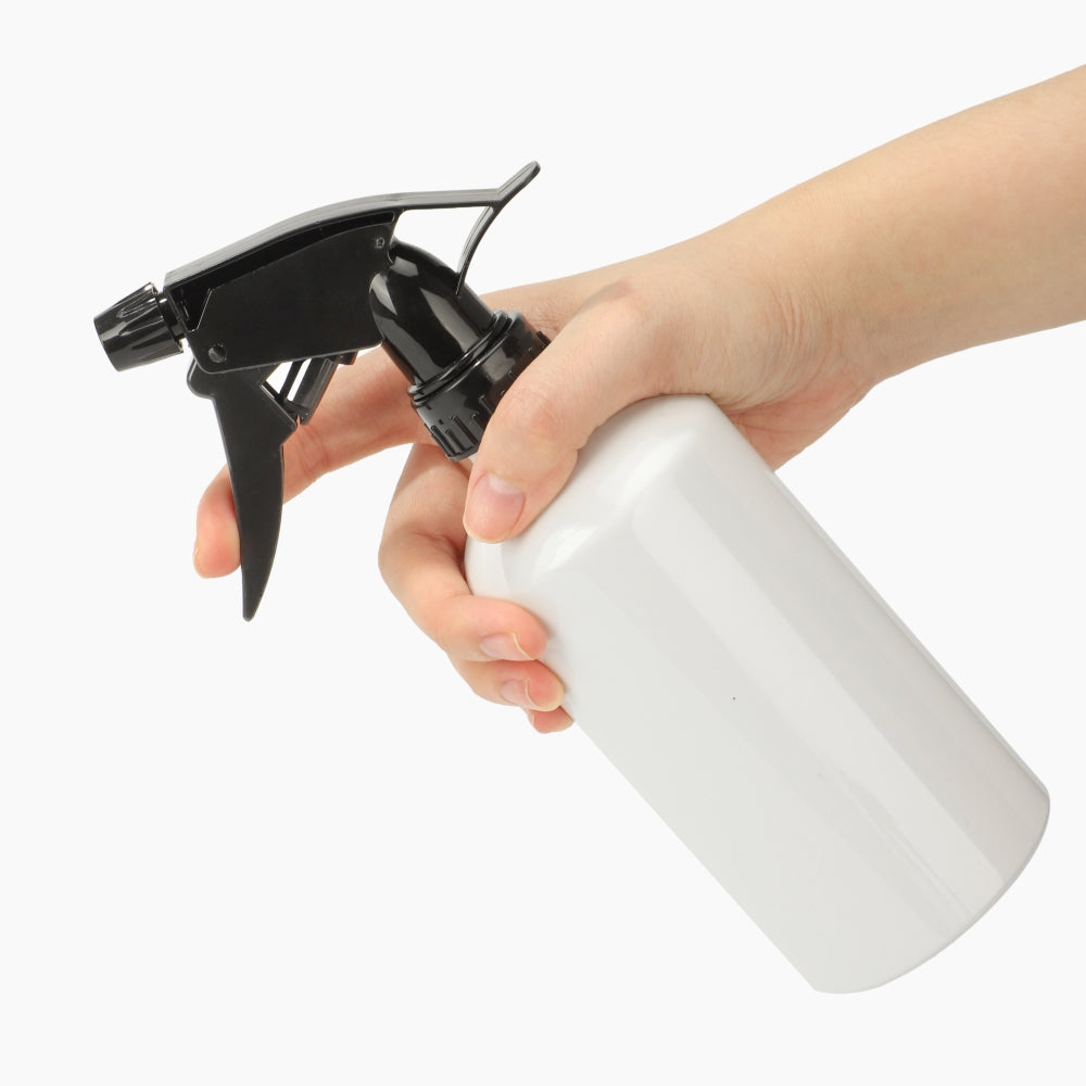 Hand holding sublimation spray bottle with black trigger for crafting and laser engraving